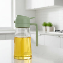 Load image into Gallery viewer, Glass oil bottle with a green lid and nozzle on a white surface
